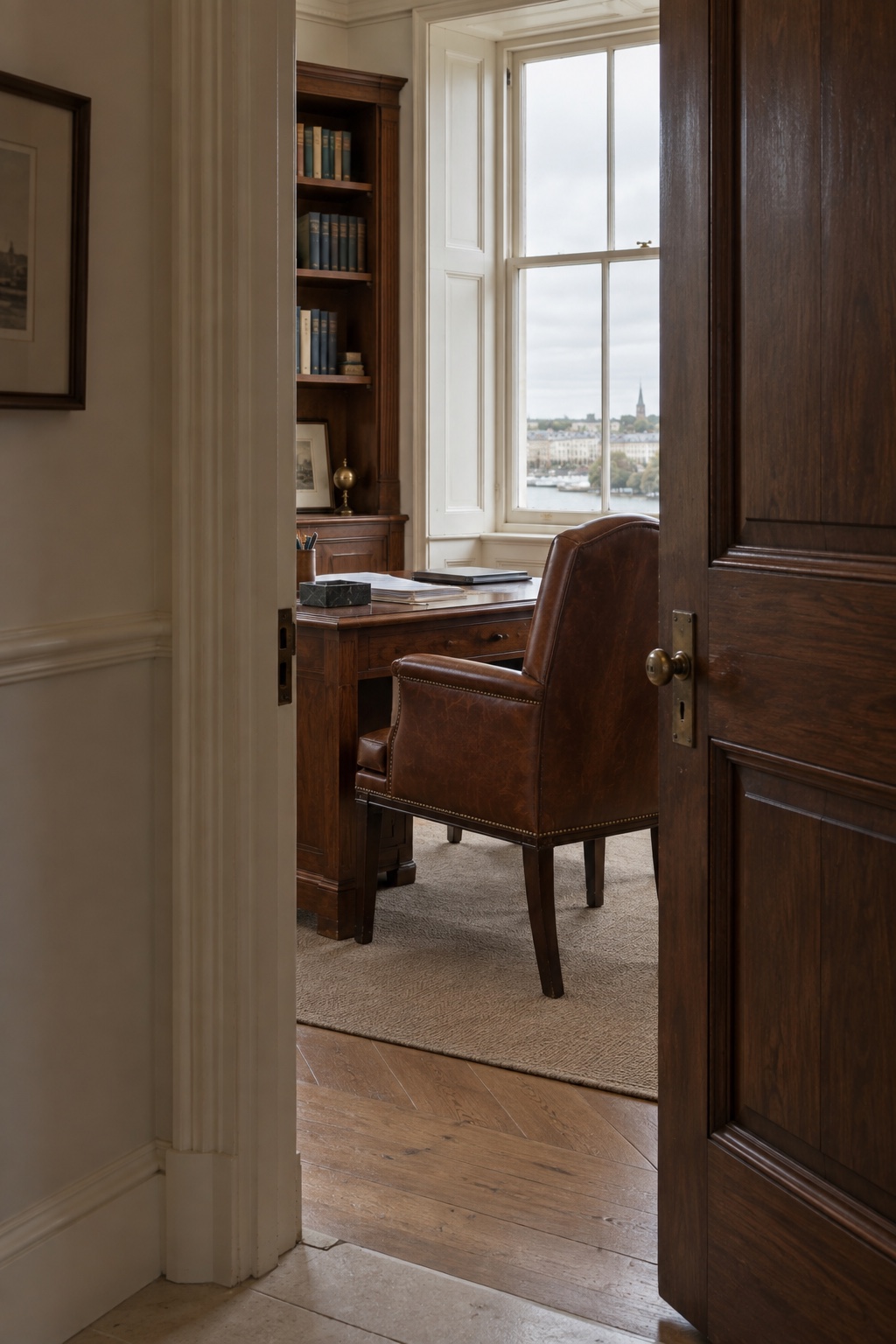 Partly open walnut door leading into a quiet meeting room