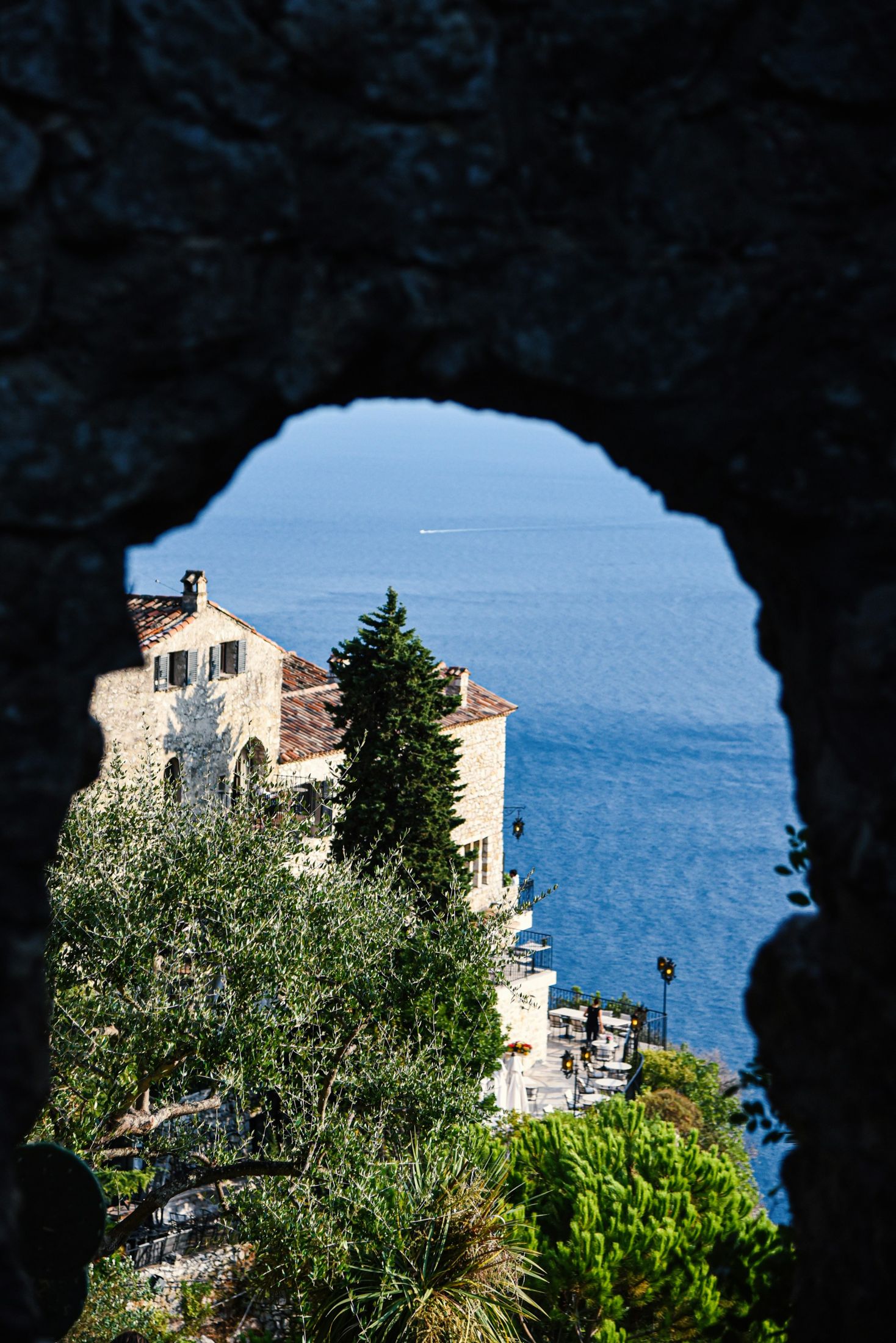Stone arch framing Mediterranean architecture and the sea in Èze, France