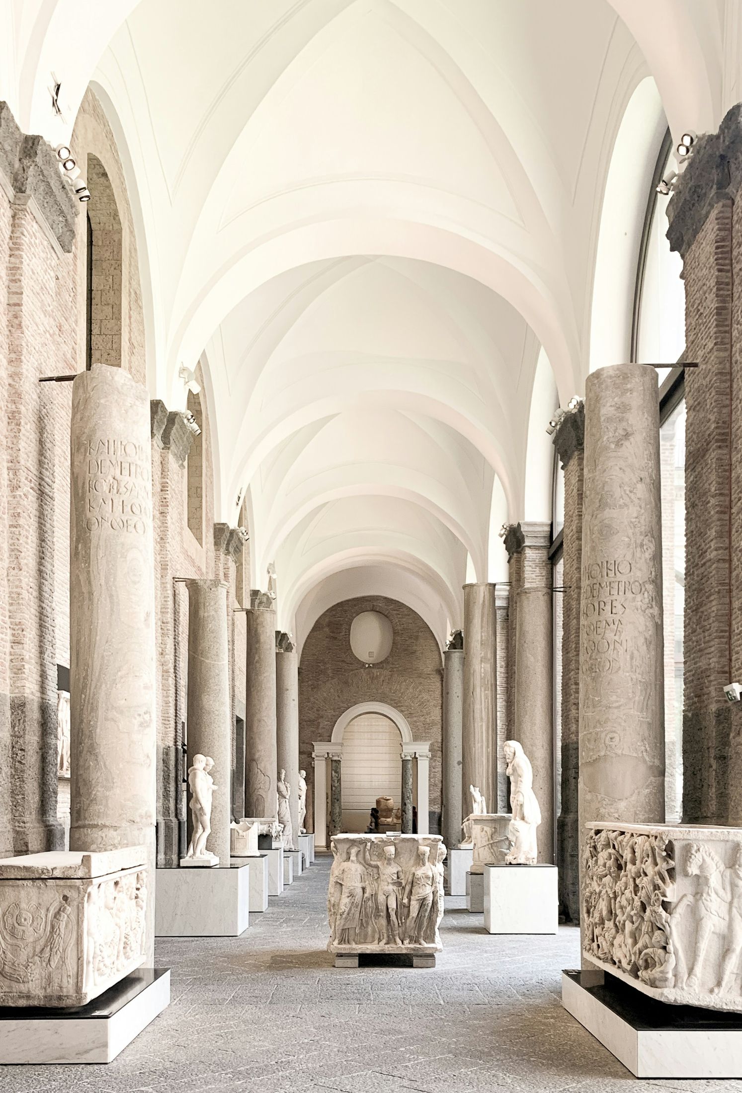 Classical sculptures and stone columns in a museum gallery in Naples, Italy